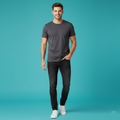 Man wearing a gray t-shirt and black jeans on a teal background