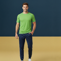 Man wearing a green athletic shirt and navy pants on a two-tone background