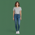 Woman wearing a gray t-shirt and blue jeans on a green background
